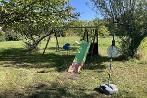 A playground with a swing set, a slide, and a badminton net. - Maffone la laupie gîte COCO (La Laupie)