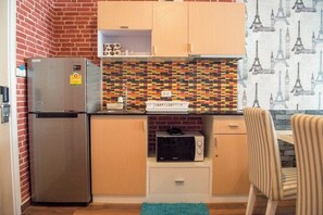A compact kitchen with a refrigerator, microwave, and a tiled backsplash. - F305 2-bedroom apartment in lovely with Playground and Kidclub near Beach (Nongkae)