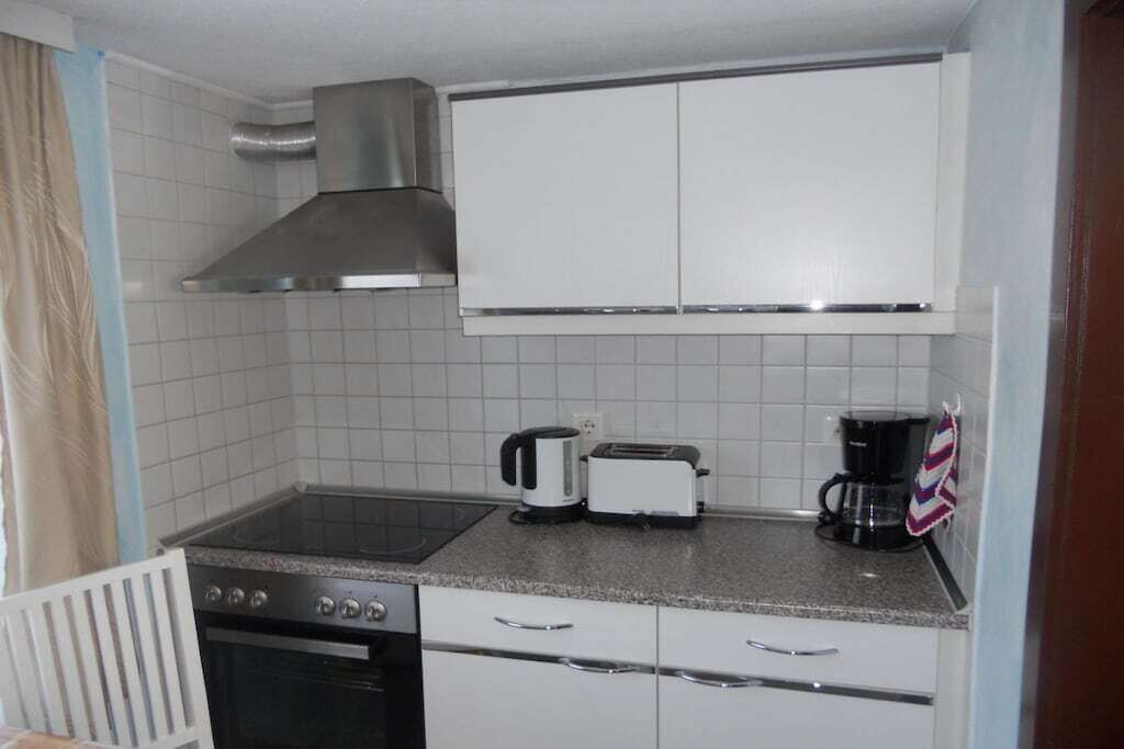 Een kleine keuken met een fornuis, broodrooster en koffiezetapparaat.