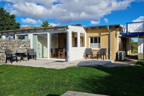 Een modern huis met een glazen patio, een stenen muur en een bakstenen gevel.
