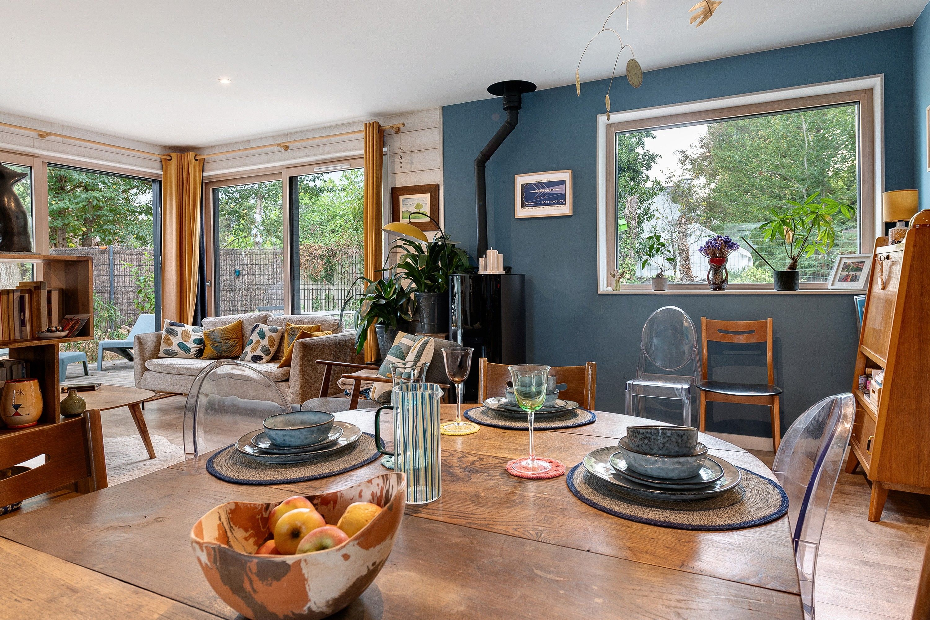 Una habitación luminosa con una mesa de comedor preparada para cuatro personas, rodeada de asientos cómodos.