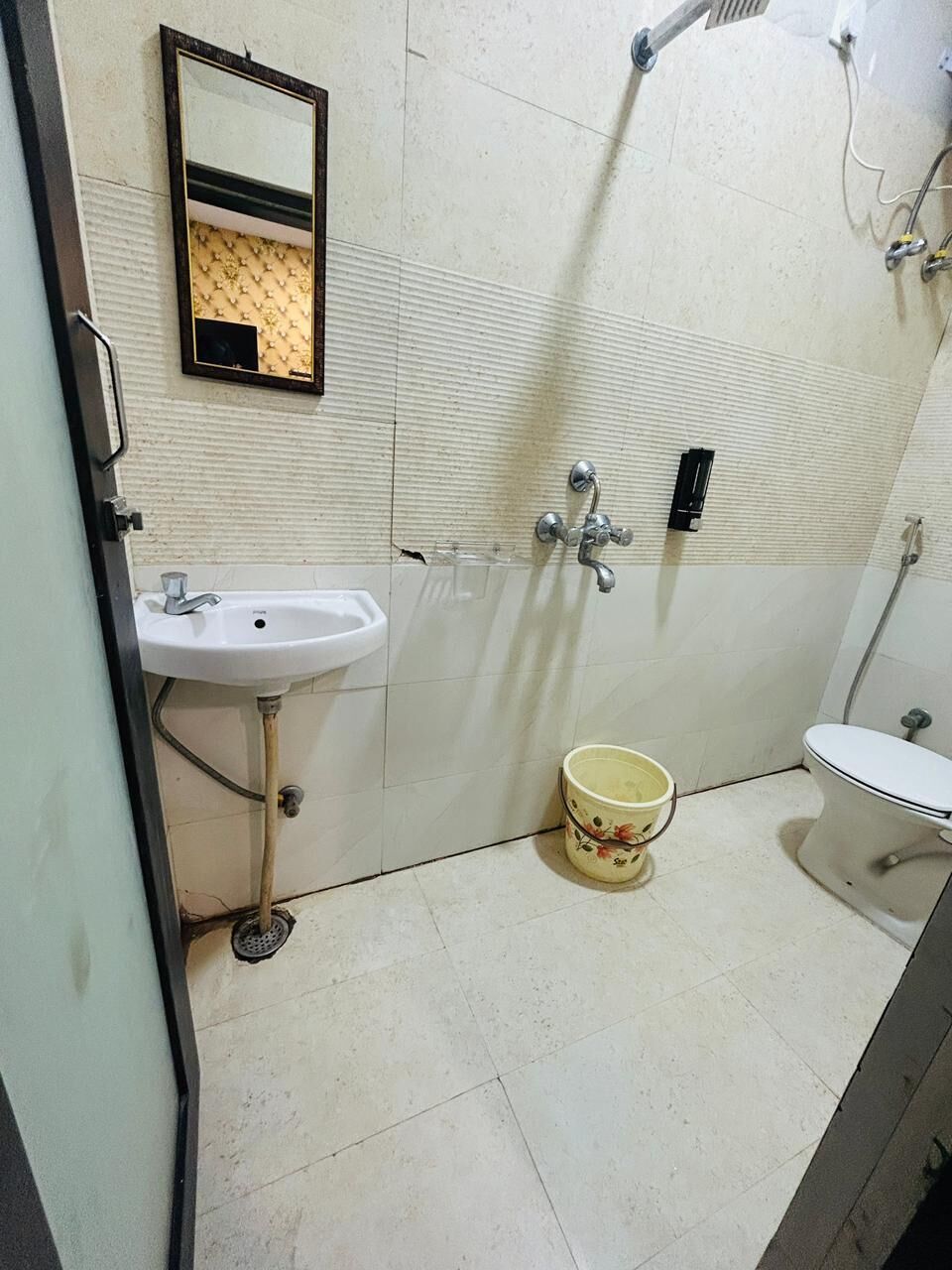 Un baño con lavamanos, inodoro y espejo.