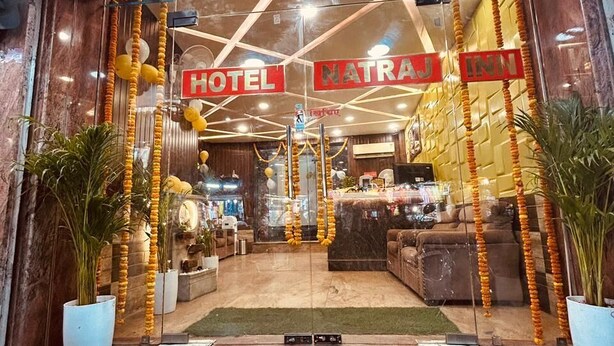 A hotel entrance with a reception desk, a staircase leading to the lobby, and a sign reading 'Natraj Inn'. - HOTE NATRAJ INN  (Varanasi)