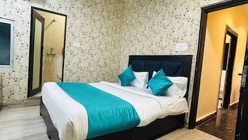 Un dormitorio con cama, ventilador de techo, ducha y piso de baldosas.