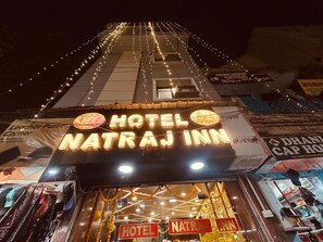 The exterior of Hotel Natraj Inn with a prominent sign, a visible entrance, and string lights. - HOTE NATRAJ INN  (Varanasi)