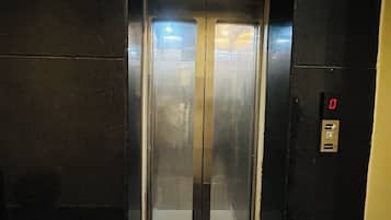 An elevator with a digital display and a glass door.