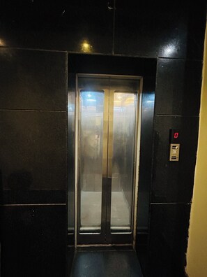 An elevator with a digital display and a glass door. - HOTE NATRAJ INN  (Varanasi)