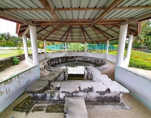 A circular stone structure with a central water feature, surrounded by a covered walkway with white pillars. - Ocean Stay & Dive (Fenfushi)