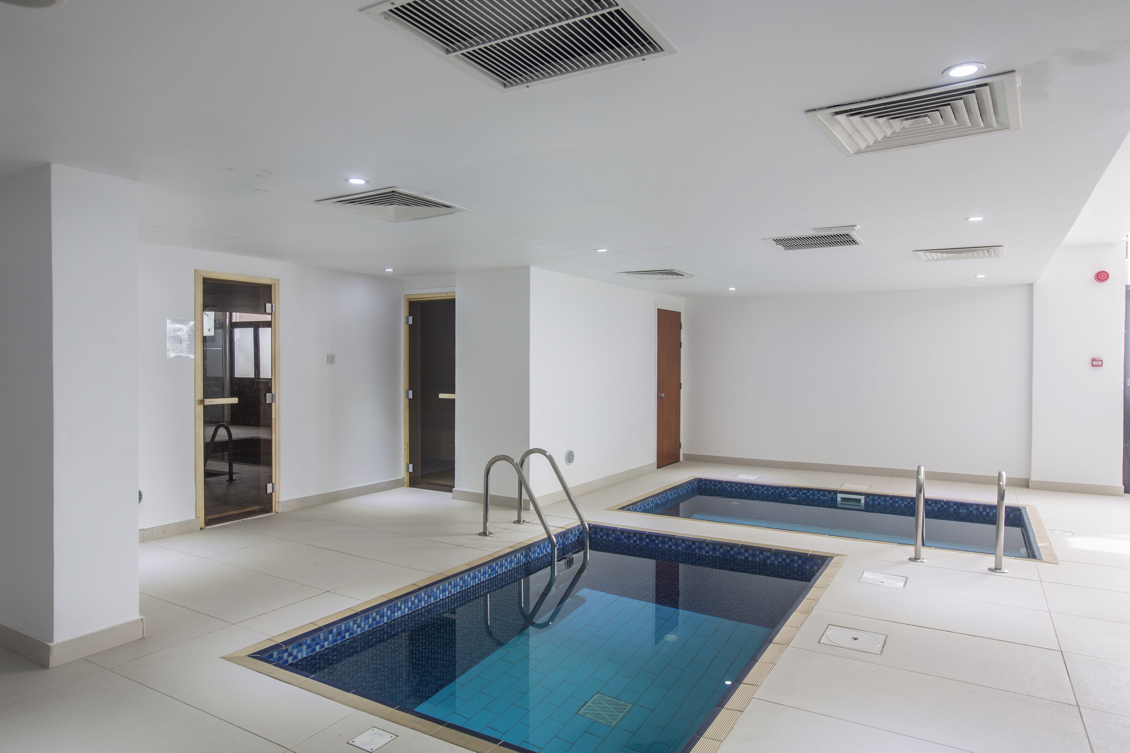Una piscina con dos carriles, una puerta y un techo con ventilación.