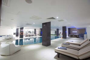Zona de piscina interior moderna amb gandules i una taquilla.