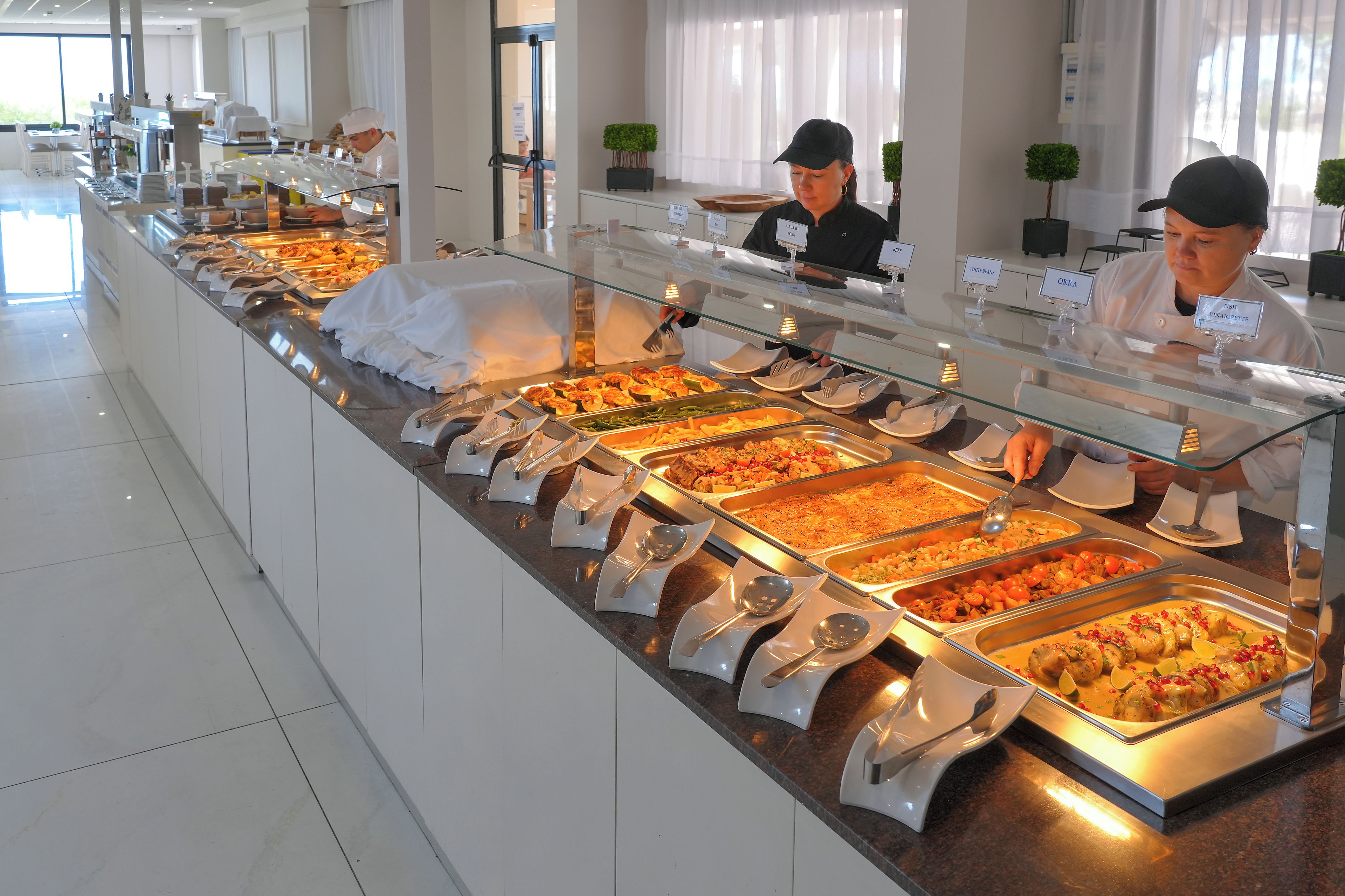 A buffet with various food options, including a section labeled 'FISH' and another labeled 'WHITE BEANS'.