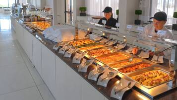 A buffet with various food options, including a section labeled 'FISH' and another labeled 'WHITE BEANS'.