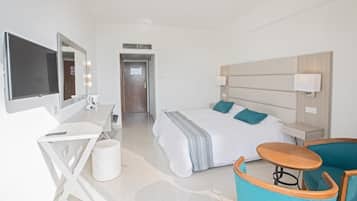 Ein Hotelzimmer mit Bett, Schreibtisch, Stuhl, Fernseher und Tür.