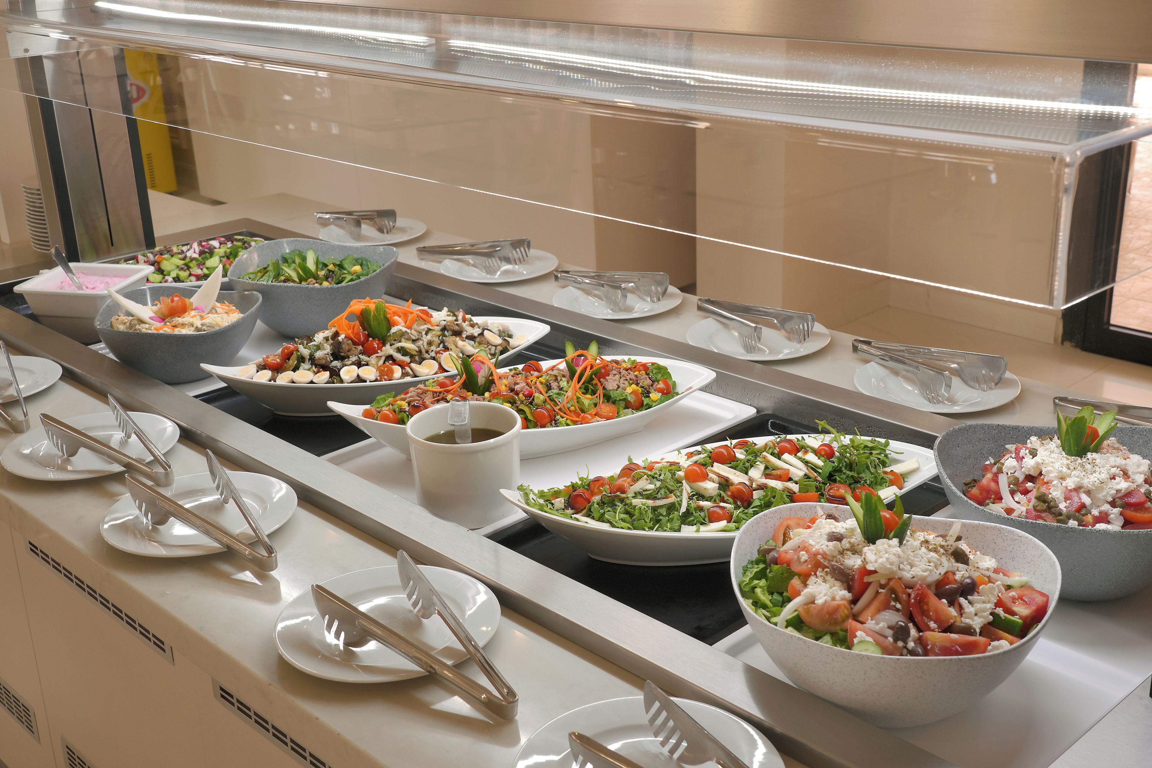 Un bufé con ensaladas variadas y una estación de café.