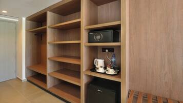 Una habitación de hotel con estanterías de madera, un minibar y un refrigerador pequeño.