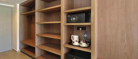 Una habitación de hotel con estanterías de madera, un minibar y un refrigerador pequeño.