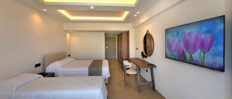 A hotel room with two beds, a desk, a chair, a flat-screen TV, and a painting on the wall.