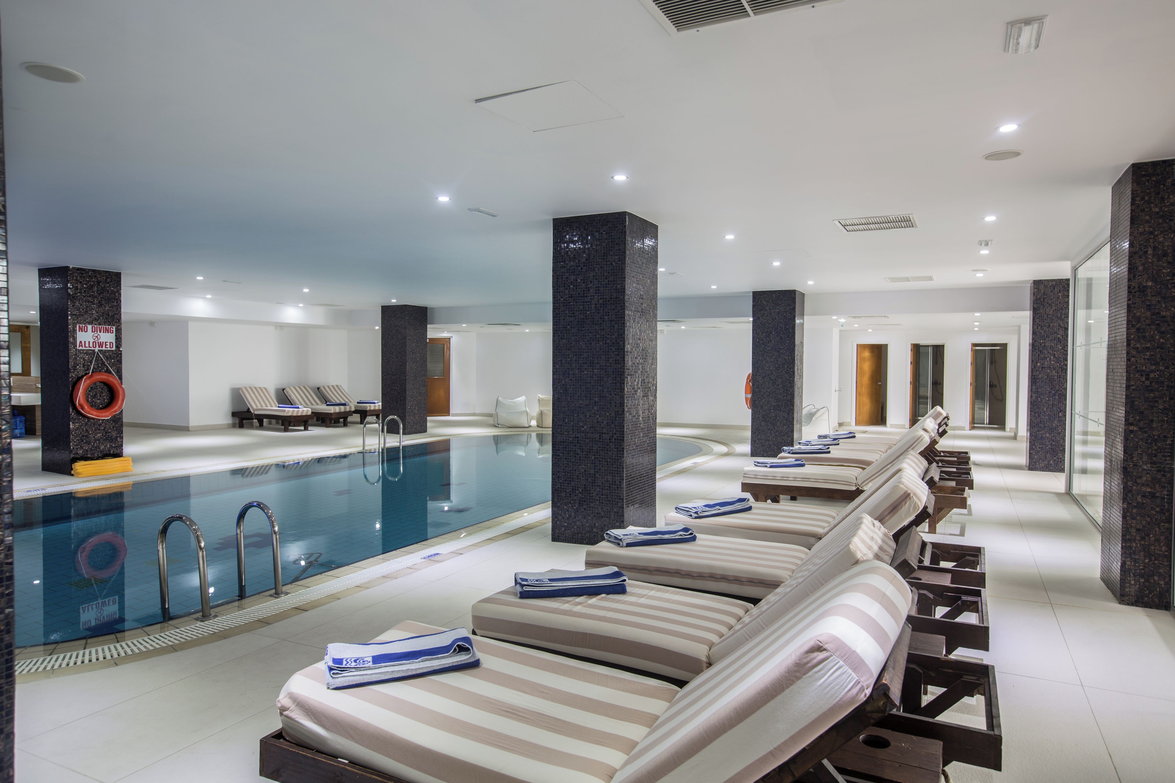 A hotel pool area with lounge chairs and a swimming pool.