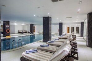 A hotel pool area with lounge chairs and a swimming pool.
