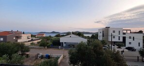 A residential area with modern buildings, a clear sky, and a body of water in the background. - Studio Apartment No. 3 (Biograd na moru)