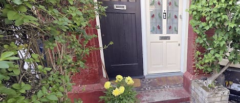 En sort dør med en hvid dør ved siden af, begge med glasruder og et nummer på skiltet.