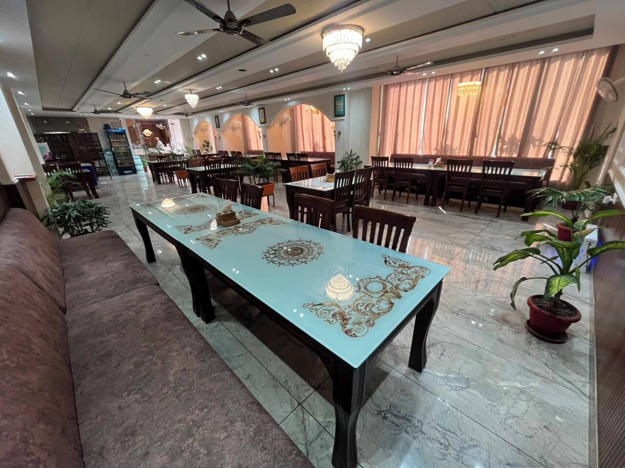 A spacious dining area with a long table, multiple chairs, and a ceiling fan.