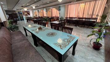 A spacious dining area with a long table, multiple chairs, and a ceiling fan.