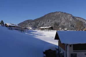 Un pueblo cubierto de nieve con edificios y una montaña al fondo.