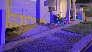 Una casa moderna amb un garatge, un porxo i una entrada ben il·luminada.