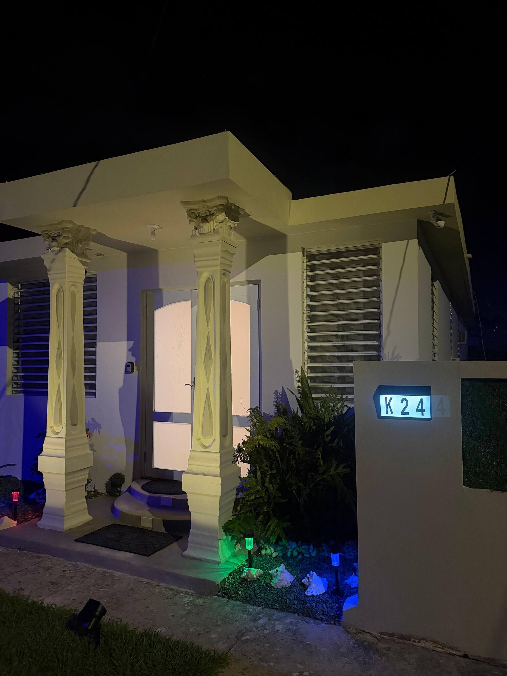 A modern house with a porch, columns, and a sign reading 'K24'.