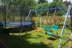 A playground with a trampoline, swings, and a bench. - Holiday apartment with 2 bedrooms (Pottenstein)