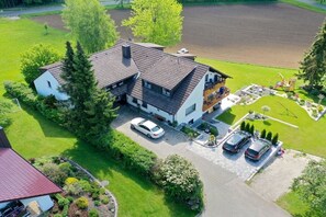 Ein zweistöckiges Haus mit Auffahrt, Carport und gepflegtem Rasen.