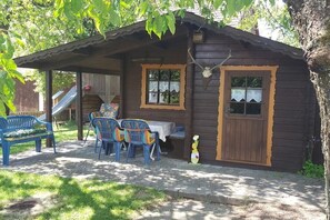 Eine Holzhütte mit Veranda, Tisch und Stühlen.