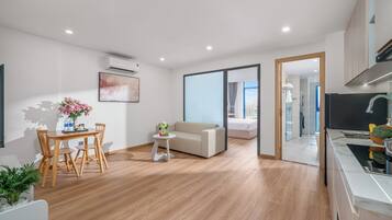 Una sala de estar moderna con comedor, un sofá, una cama y una cocina con vistas.