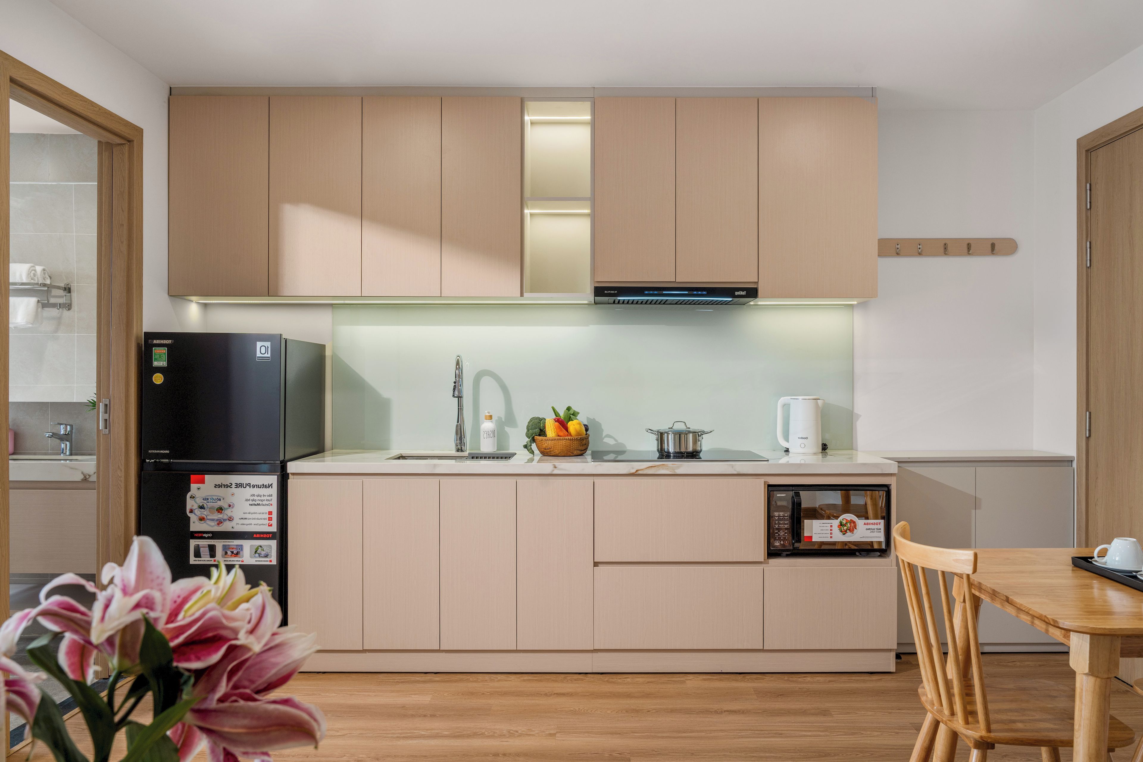 Una cocina moderna con refrigerador, estufa y microondas integrados.