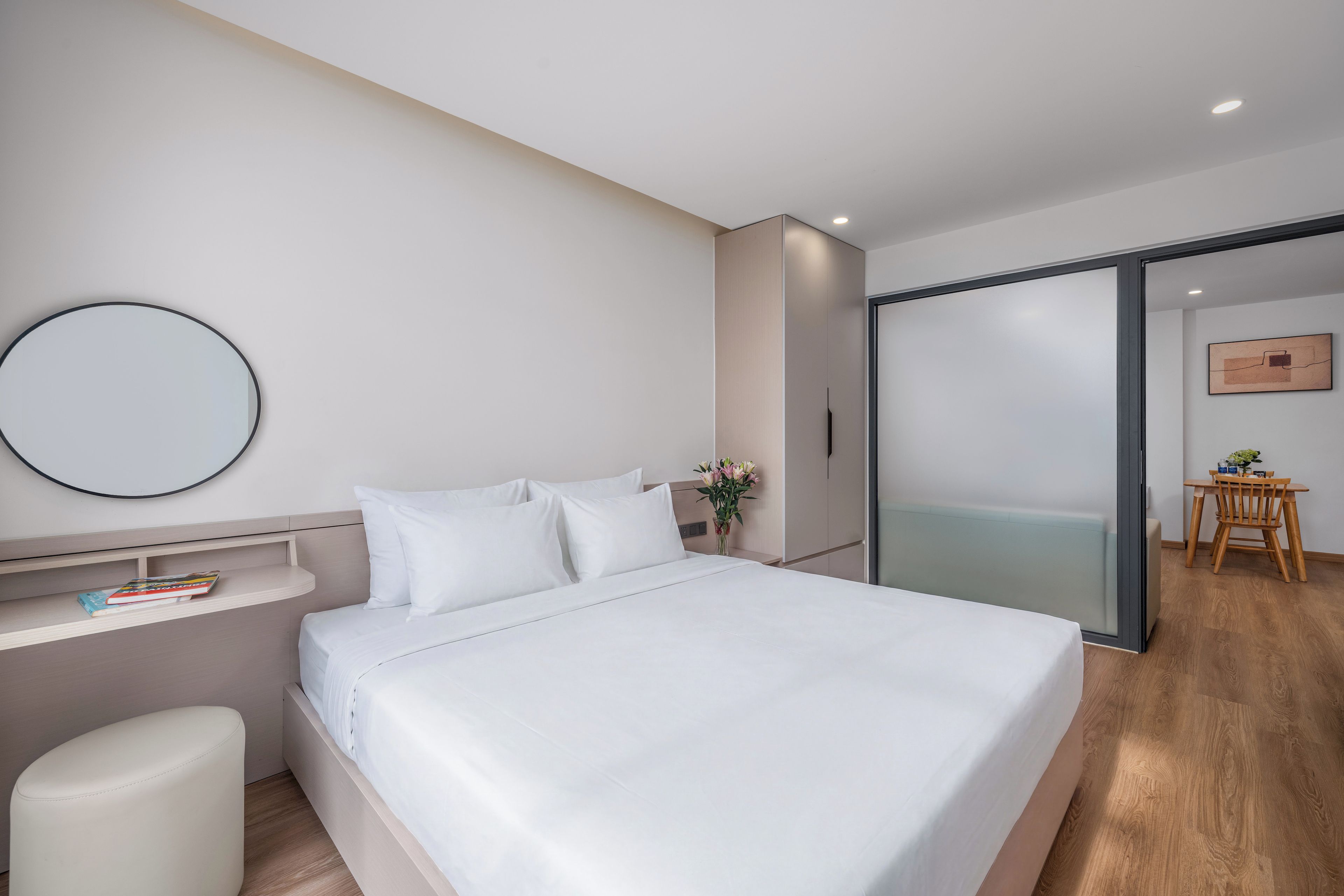 Un dormitorio moderno con cama, mesita de noche y espejo.