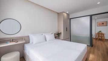 Un dormitorio moderno con cama, mesita de noche y espejo.