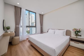 Una habitación de hotel moderna con una cama grande, una mesita de noche, un espejo y una ventana con cortinas.