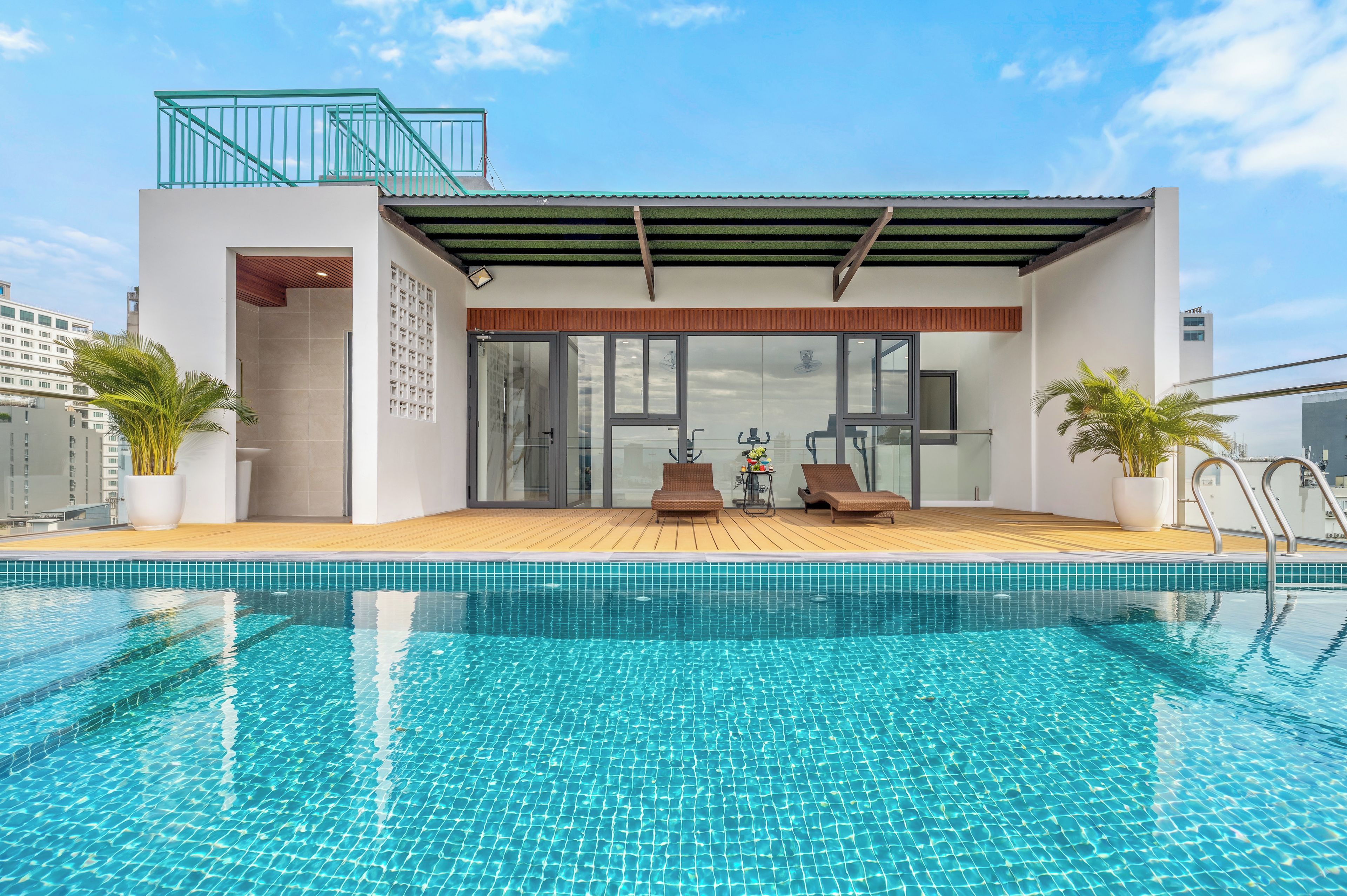 A modern building with a swimming pool, glass doors, and a covered patio area.
