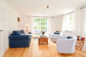 A living room with a sofa, armchair, and a coffee table. - Old fisherman's house - large apartment (Born a. Darß)