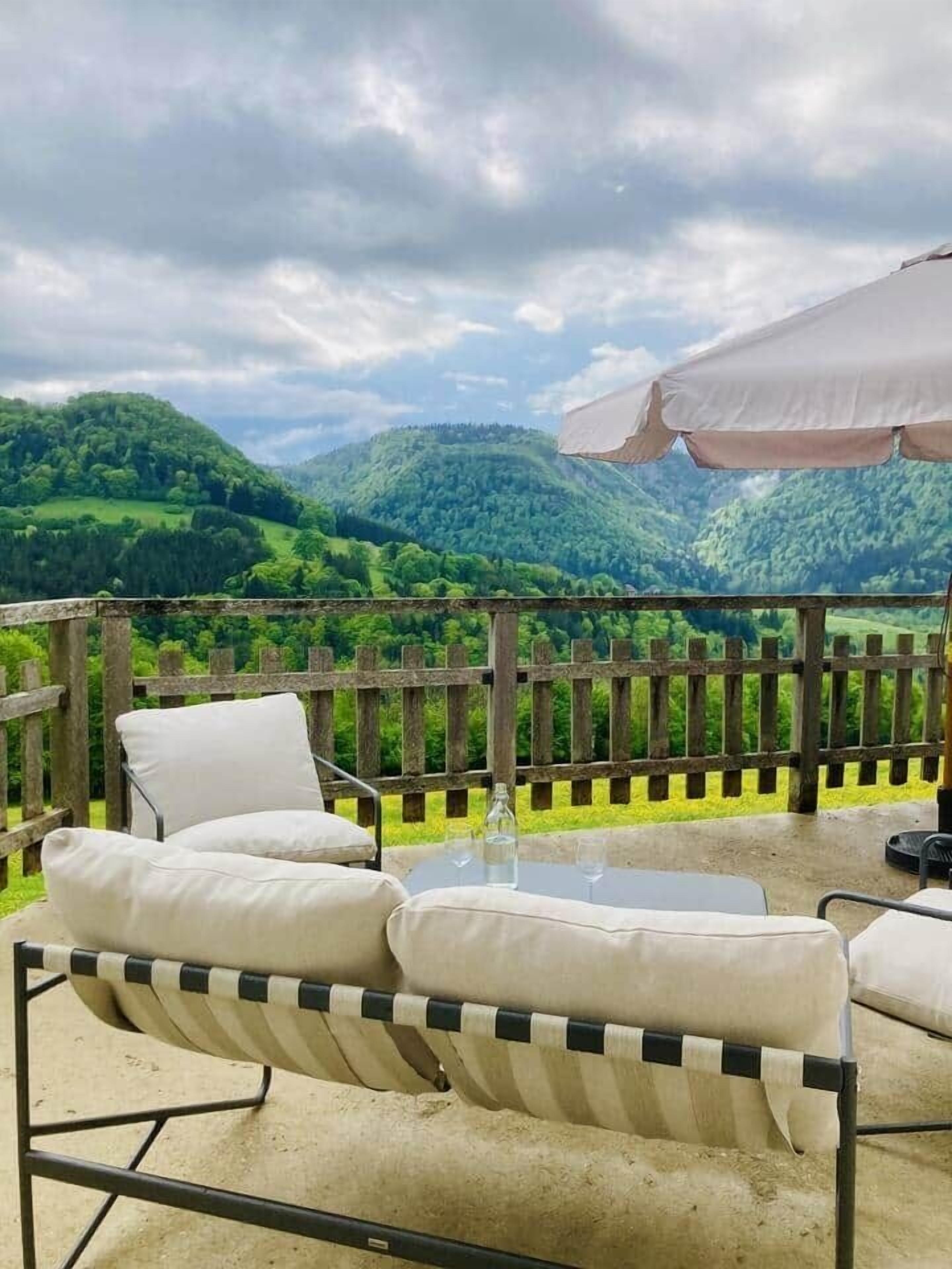 An outdoor seating area with a view of green hills.
