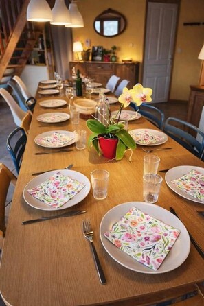 A dining table set with plates, glasses, and cutlery, with a potted plant and a mirror on the wall. - The Balcons du Haut-Doubs in the Heart of the Natural Park (Vaucluse)