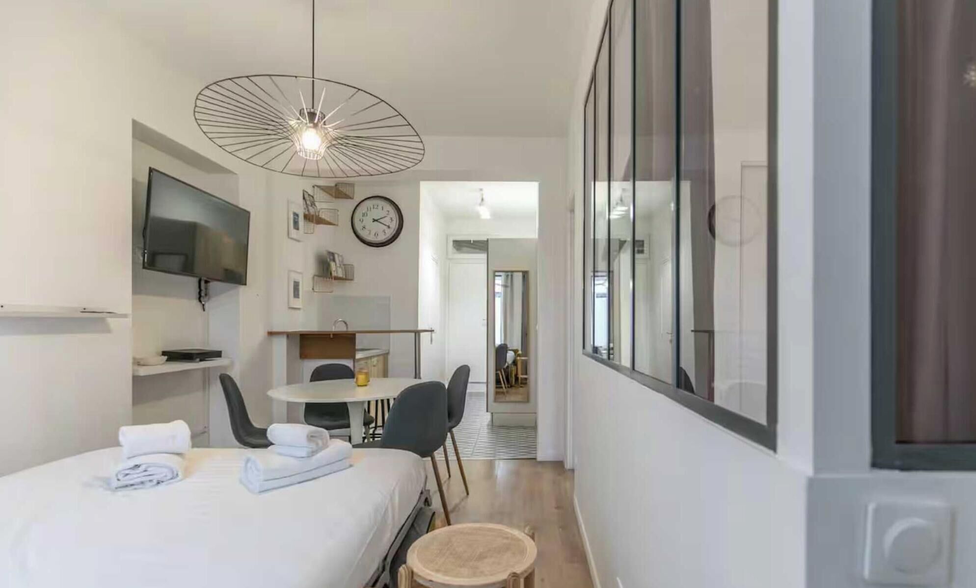 Een moderne hotelkamer met een bed, een bureau, een stoel, een televisie en een eethoek.