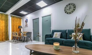 A modern reception area with a wooden reception desk, a green sofa, a clock, and a door labeled 'Camizze'. - Spacious Apartment -3BR/10P- Montreuil near Paris (Montreuil)