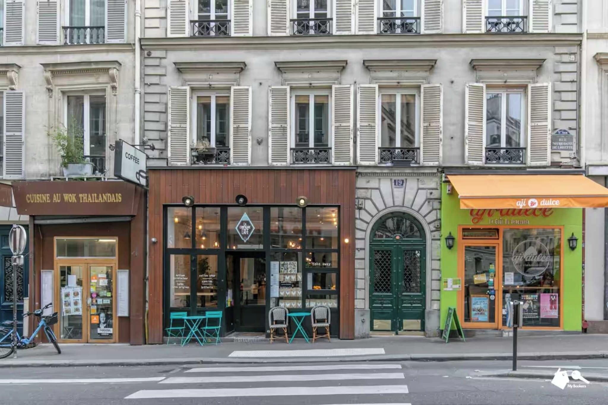 Et gadesyn med en café der hedder 'COFFEE' og en butik med skiltet 'CUISINE AU WOK THAILANDAIS'.