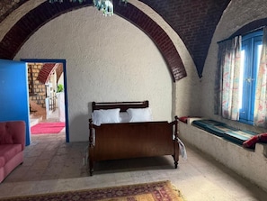 A room with a bed, a red sofa, a window with curtains, and an arched ceiling. - VILLA EL SAFIR FARMHOUSE (Beheira Governorate)