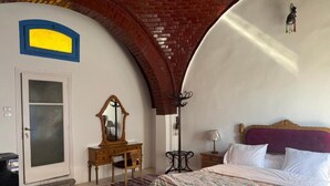 Un dormitorio con cama, cómoda, espejo, lámpara y puerta.