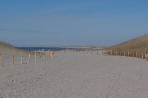 A sandy beach path with wooden posts on the sides, leading to the sea. - Holiday apartment with 2 bedrooms (Petten)