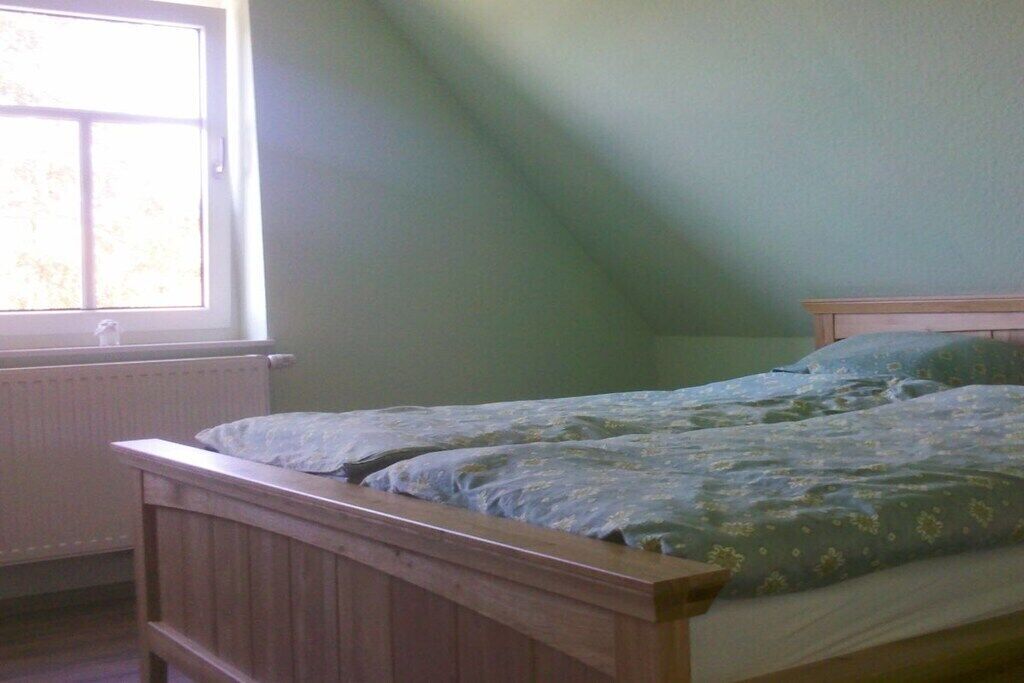 Un dormitorio con una cama individual, una ventana y un radiador.