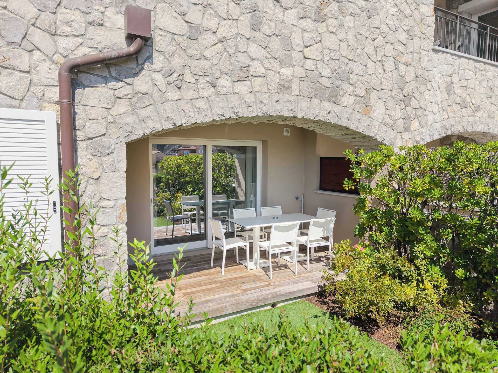 Un bâtiment en pierre doté d’un patio comprenant une table et des chaises.